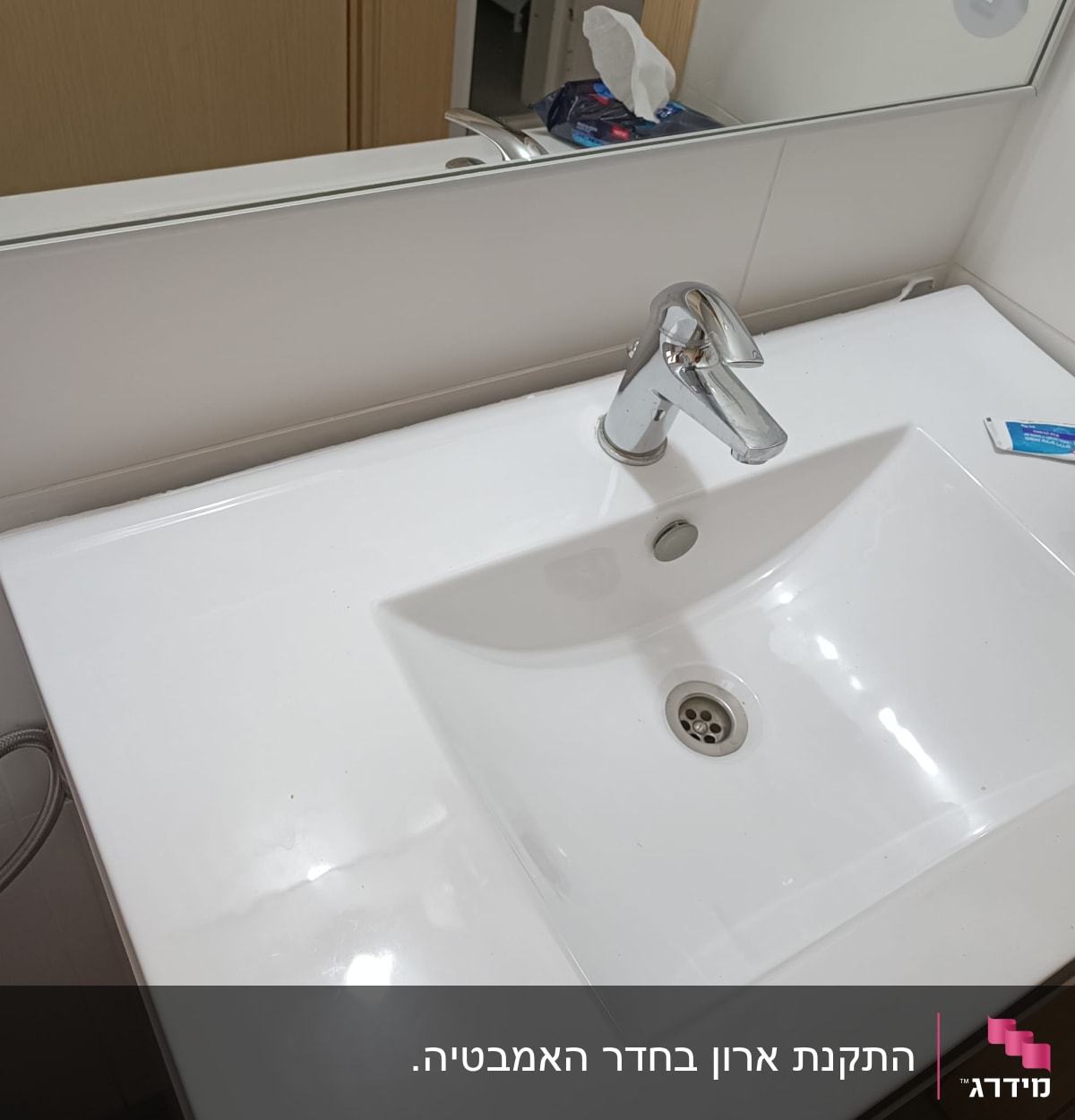 כיור לבן עם ברז כרום בחדר אמבטיה